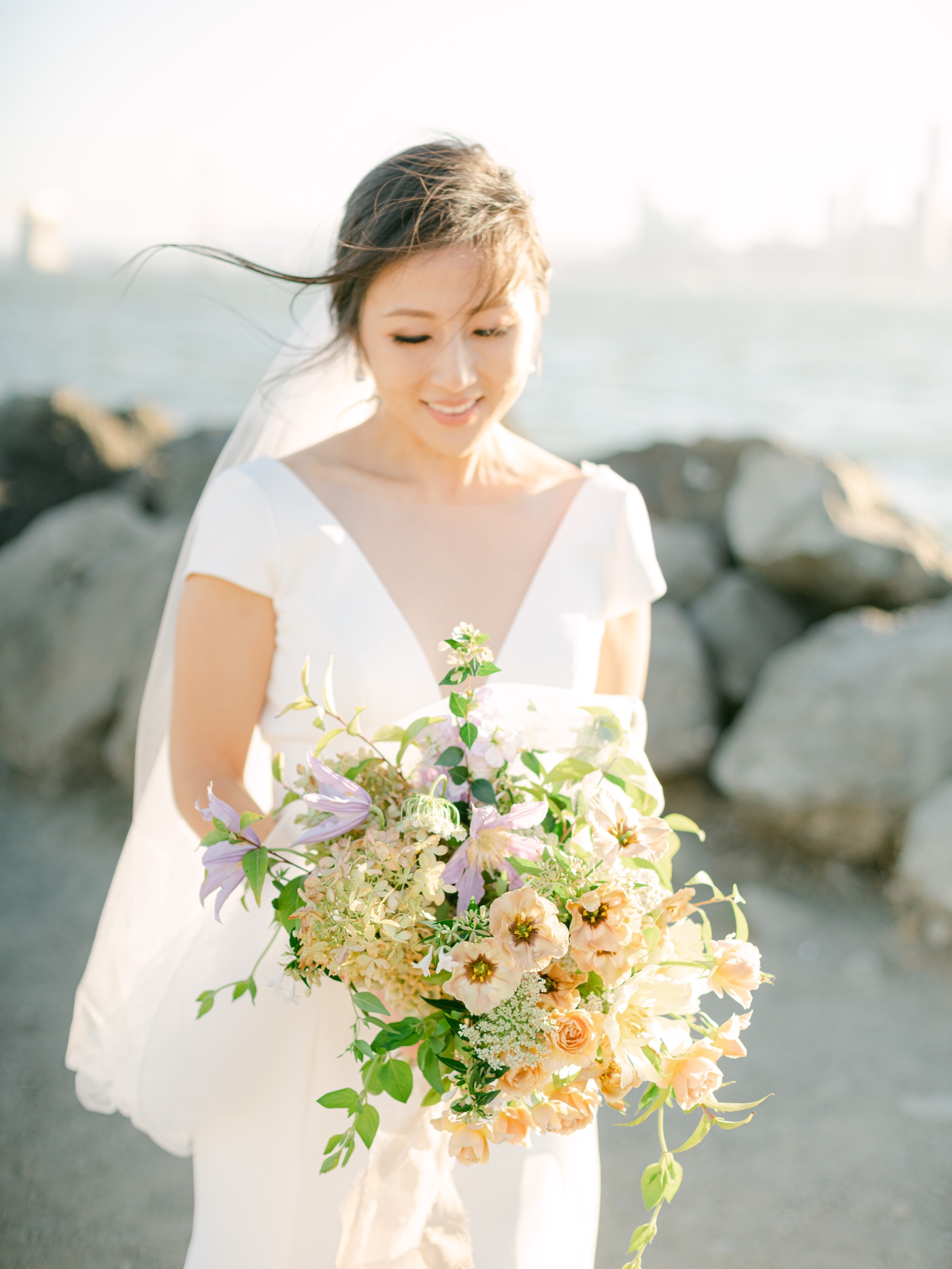 Bridal bouquet filled with garden roses, peach lisianthus, and greenery by Bough and Twig