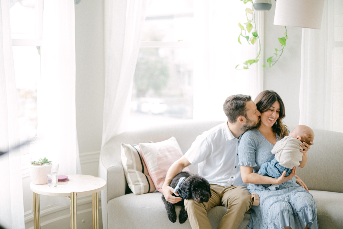 Family sitting on a modern beige couch for in-home family session